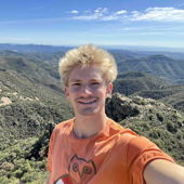 Evan taking a selfie on the top of a mountain in Spain.