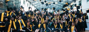 Students celebrating graduation throwing caps in air