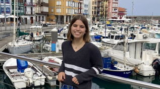 Eliza posing with boats in the background in Bilbao, Spain.