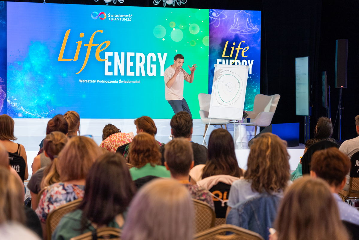 Źródło: Paweł przy flipcharcie na scenie Life Energy