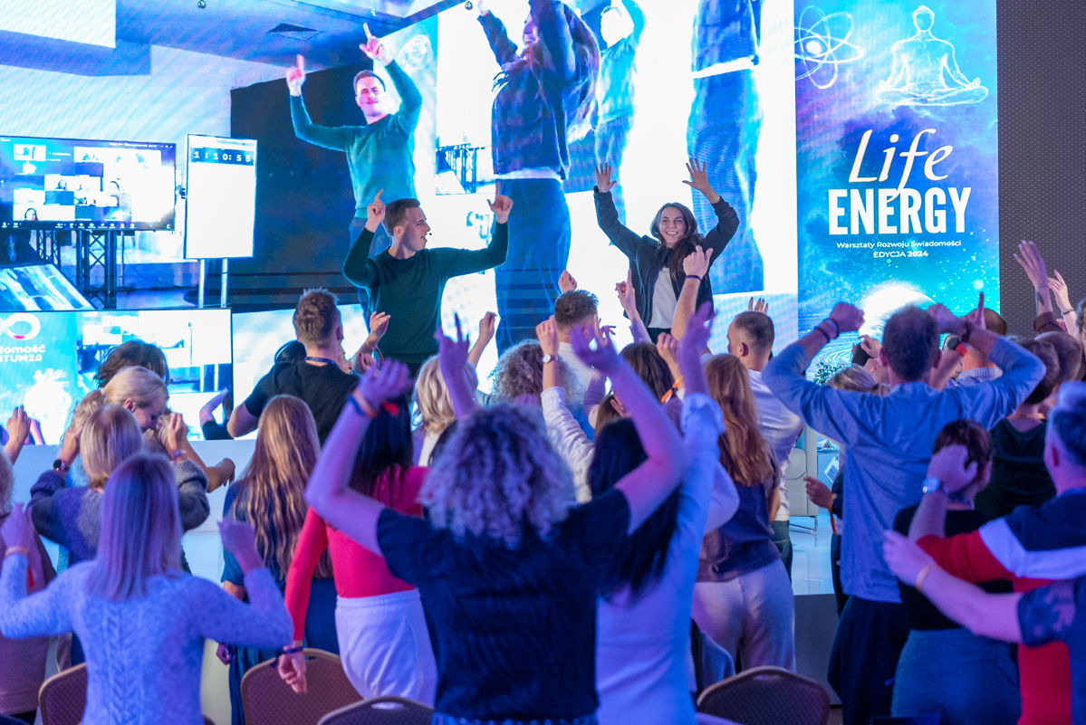 Uczestnicy i prowadzący Life Energy tańczą przed sceną