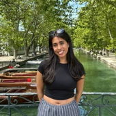 Mia standing on a bridge in front of a canal in France.