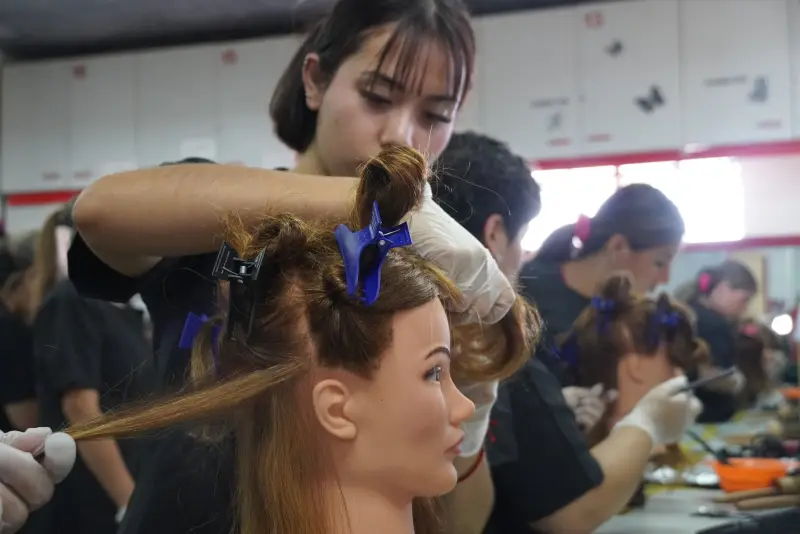 Alumna de peluquería aplicando tintura