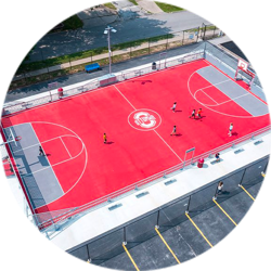 Softball field with red Tuttle High School logo lit by two LED light poles and fixtures.